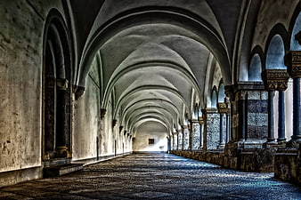 Historic stone cloister corridor with vaulted arches