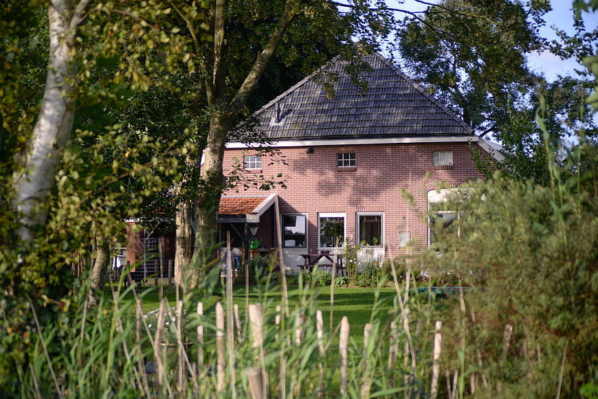 Red brick Dutch farmhouse in green countryside