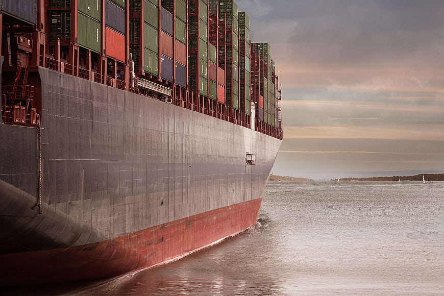 Massive Container Ship Sailing on Calm Water at Sunset