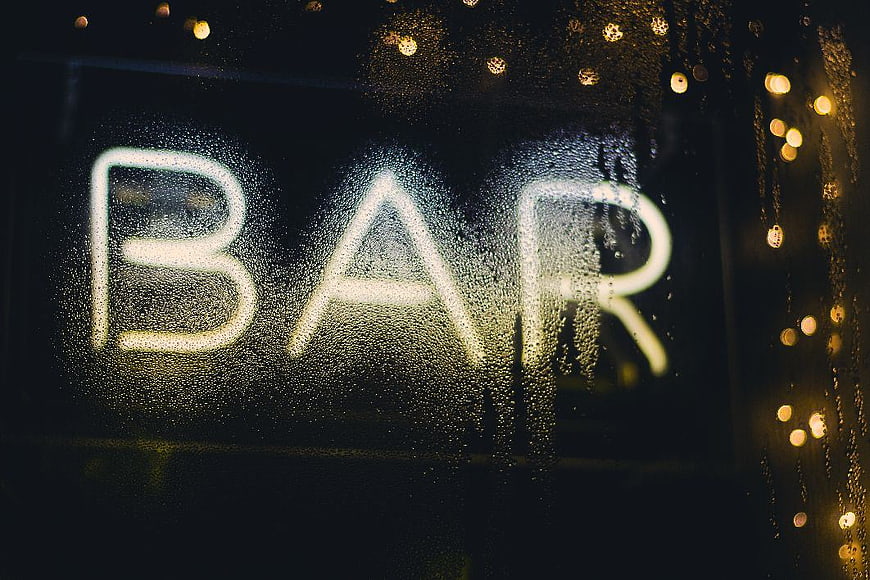 Neon Bar Sign Through Rainy Window at Night
