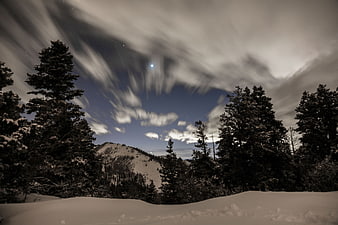 Dramatic Night Sky Over Snowy Mountain Forest