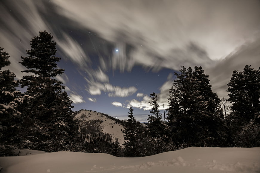 Dramatic Night Sky Over Snowy Mountain Forest