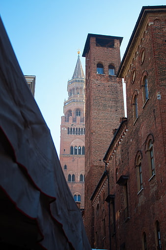 Torrazzo of Cremona seen through brick buildings
