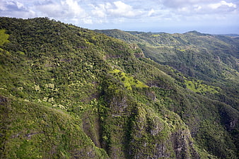 Lush green mountain ridge landscape with clouds