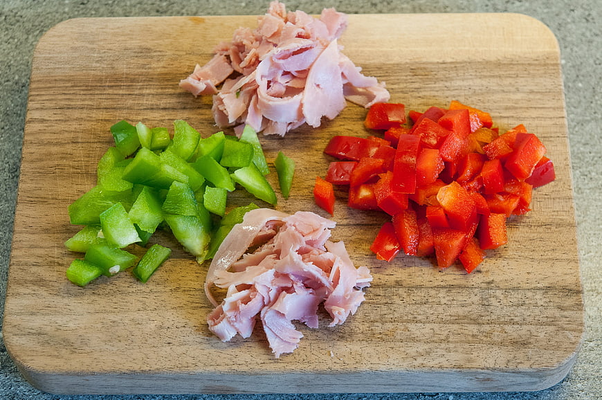 Chopped ham and peppers on wooden cutting board