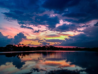 Dramatic Sunset Sky Reflection Over Calm Lake Water