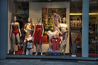 Retail store window display featuring fashion mannequins and swimwear