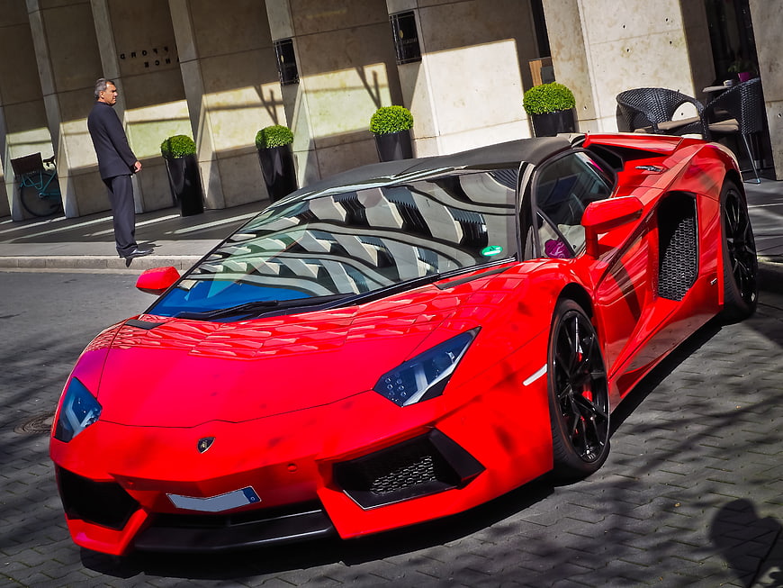 Red Lamborghini Aventador parked on city street
