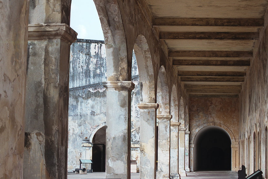 Historic stone arches and columns in an old fort corridor