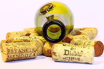 Empty wine bottle lying on pile of wine corks