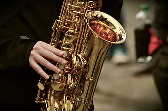 Close-up of hands playing a golden saxophone