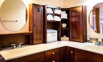 Modern bathroom vanity with dark wood cabinets and towel dispenser