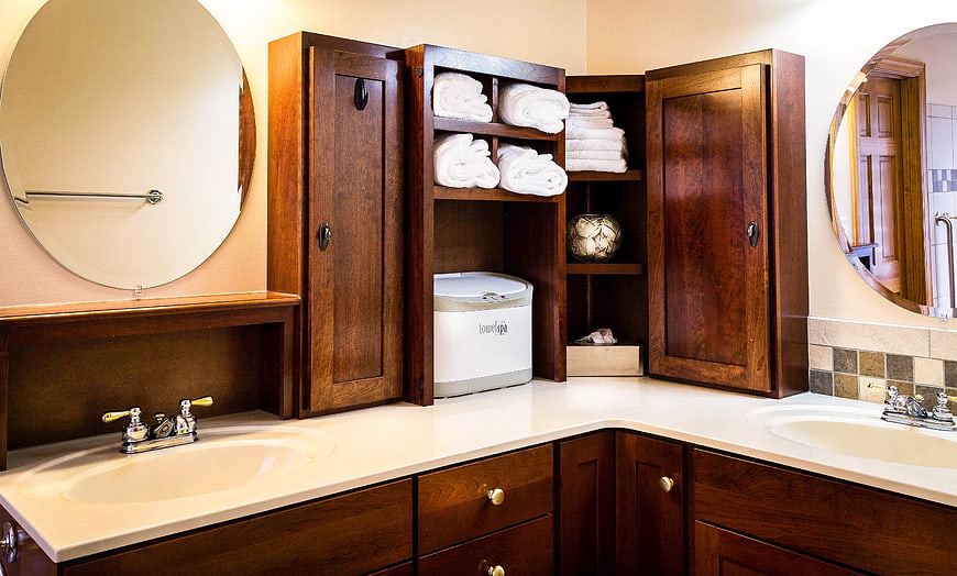 Modern bathroom vanity with dark wood cabinets and towel dispenser