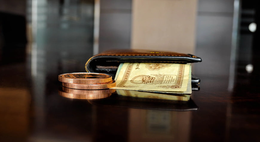 Brown Leather Wallet with Banknotes and Coins on Table