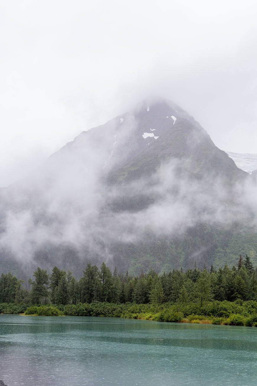 Misty Mountain Peak Overlooking Turquoise Lake and Forest