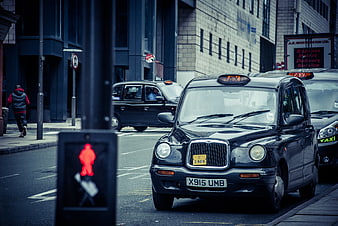 Black London Taxi Cab on Urban Street with Red Traffic Light