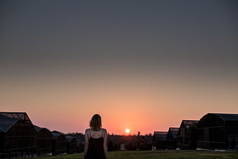 Woman Silhouette Watching Sunset Over Greenhouses