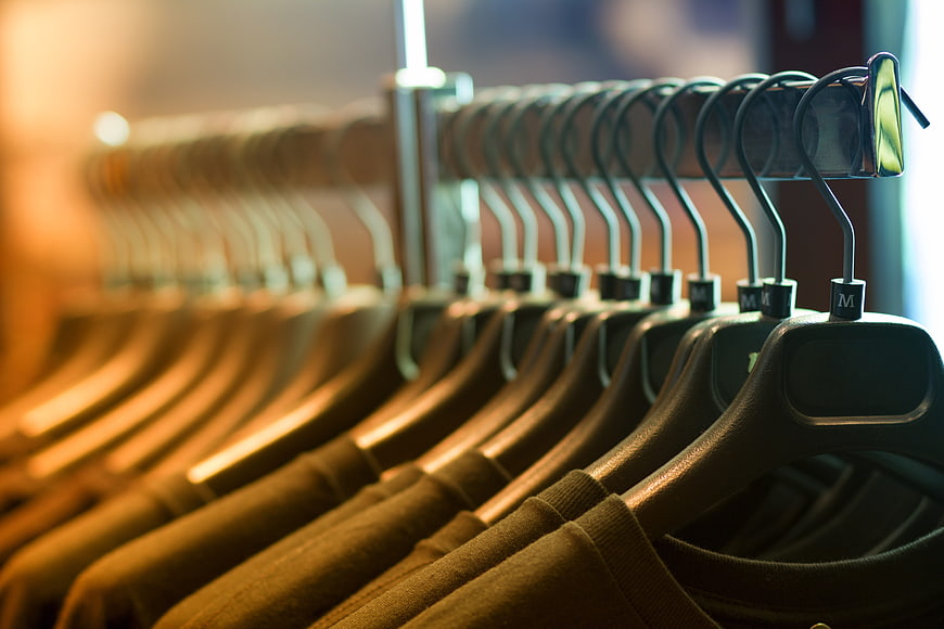 Close-up of black hangers on a clothing rack in a store