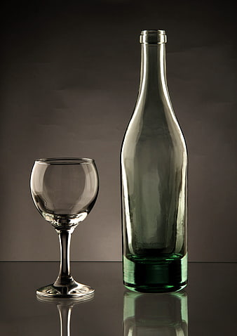 Empty Green Wine Bottle and Glass on Dark Background