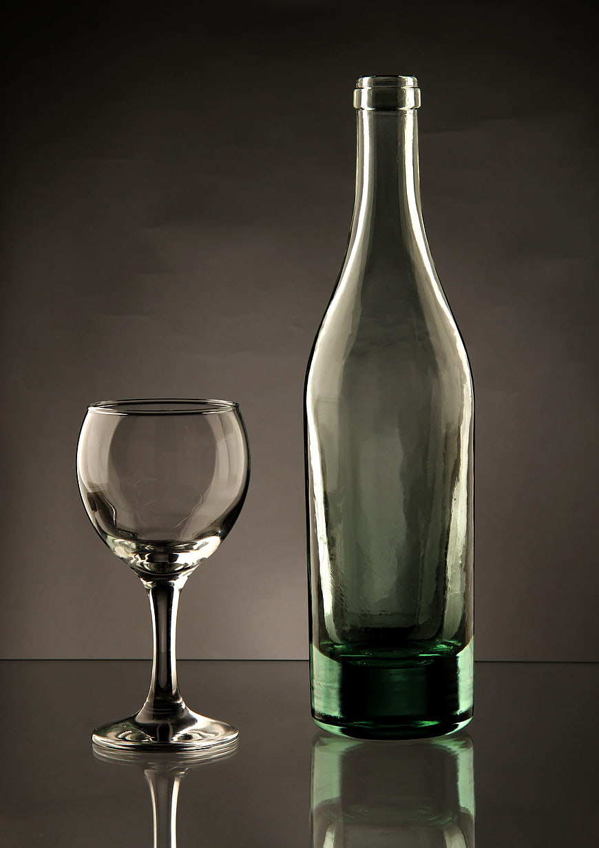 Empty Green Wine Bottle and Glass on Dark Background
