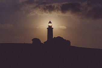 Silhouette of Lighthouse at Sunset with Dramatic Clouds
