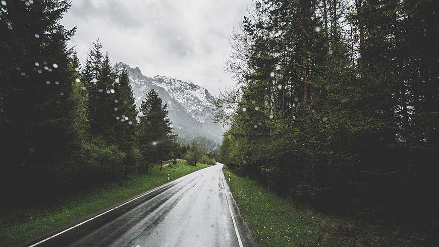Wet Mountain Road Through Forest with Raindrops