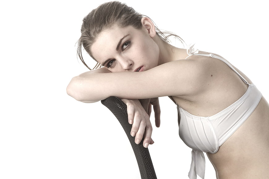 Woman in White Lingerie Leaning on Chair
