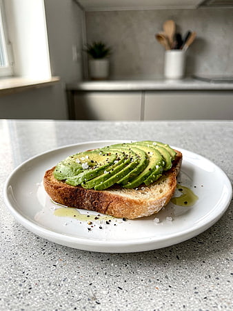Sliced Avocado Toast on White Plate in Modern Kitchen