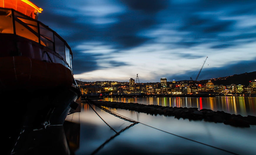 Boat Silhouette at Harbor with City Skyline at Dusk