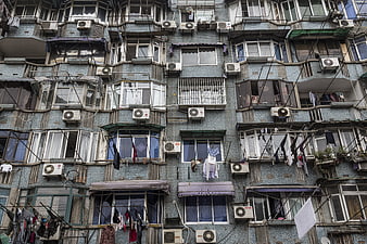 Weathered Chinese apartment facade with laundry and air conditioners