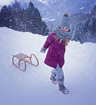 Happy Girl Pulling Wooden Sled in Snowy Mountains