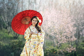 Asian Woman in Kimono with Red Umbrella Under Cherry Blossoms