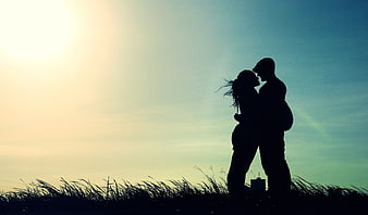 Silhouette of Romantic Couple Kissing at Sunset