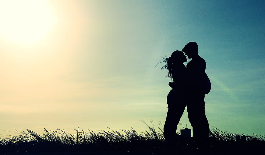 Silhouette of Romantic Couple Kissing at Sunset