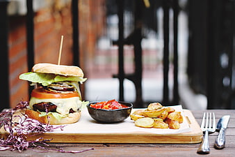 Gourmet Burger with Roasted Potatoes and Salad on Wooden Board