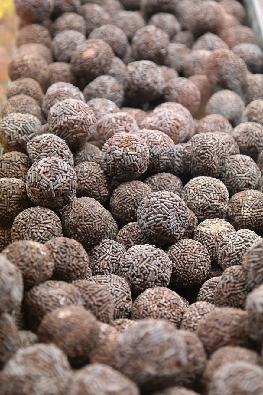 Close-up of chocolate rum balls with sprinkles in a market display