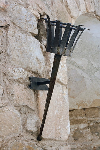 Rusty wrought iron lantern on ancient stone wall