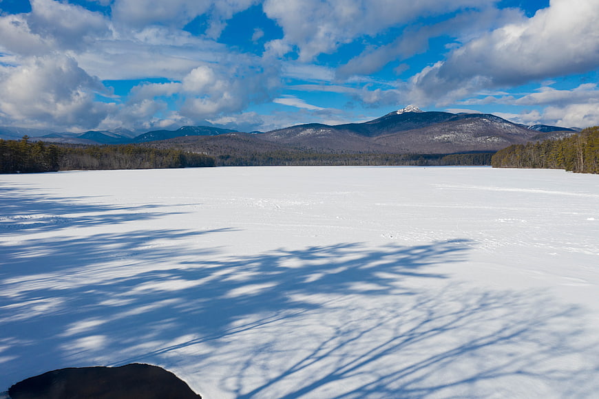 Frozen Lake Landscape with Mountain Shadows and Blue Sky