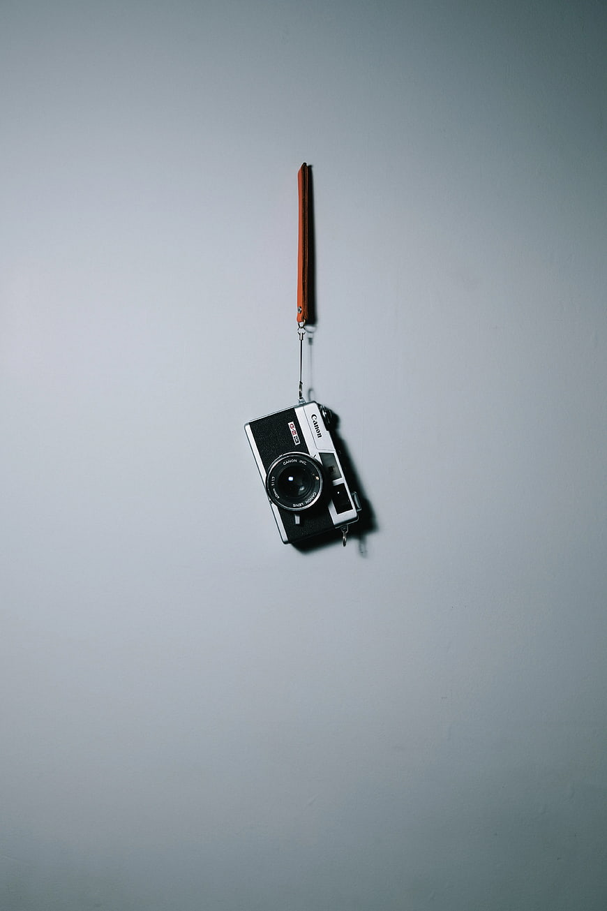 Vintage Canon Film Camera Hanging on Gray Wall