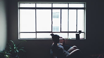 Silhouette of Woman Sitting by Bright Window