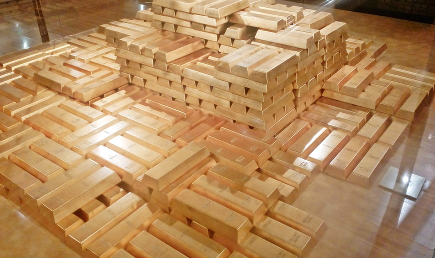 Stacks of gold bars in a secure vault display