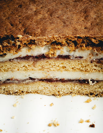 Close-up of layered cake with crumble topping and cream filling