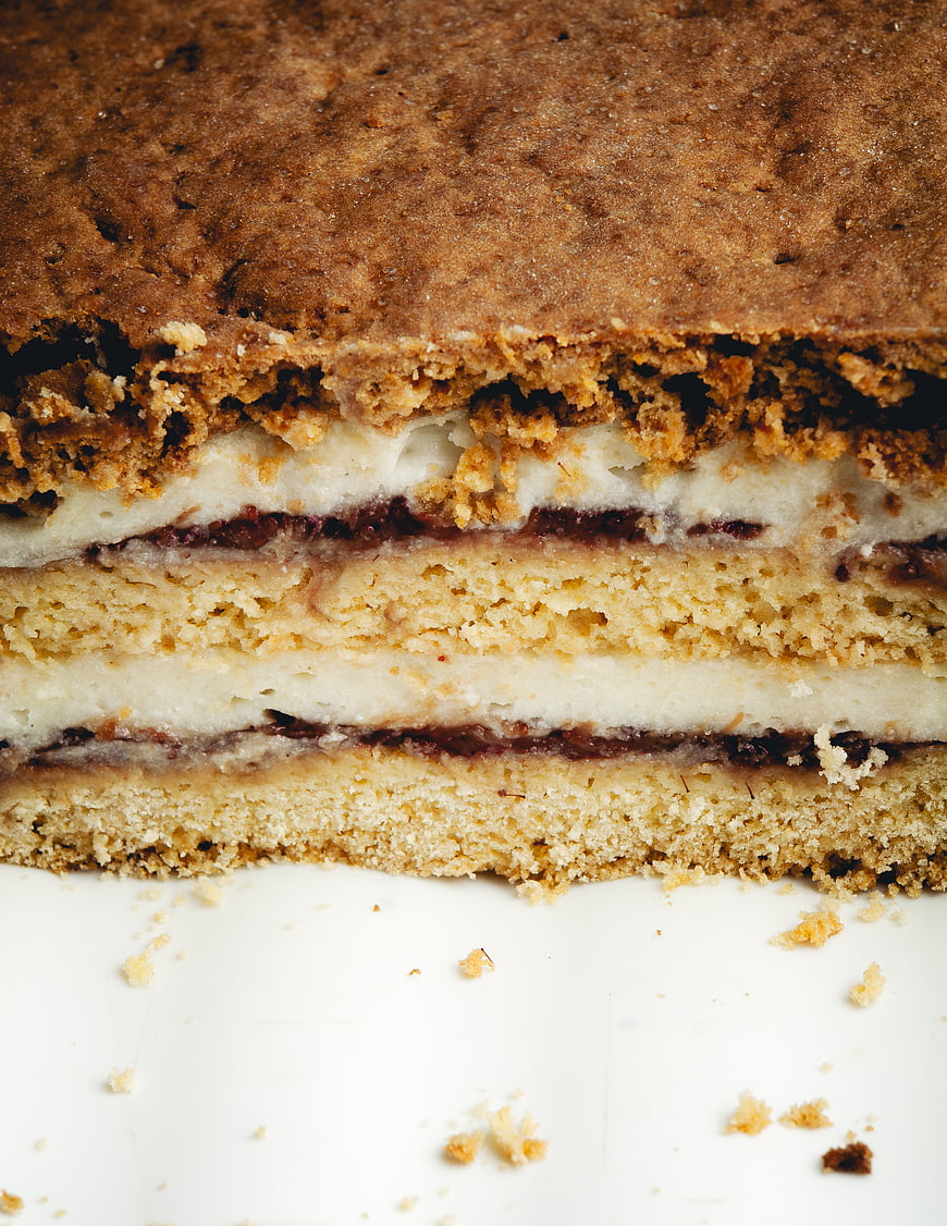 Close-up of layered cake with crumble topping and cream filling
