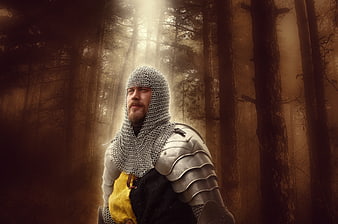 Medieval Knight in Chainmail Armor Standing in Misty Forest