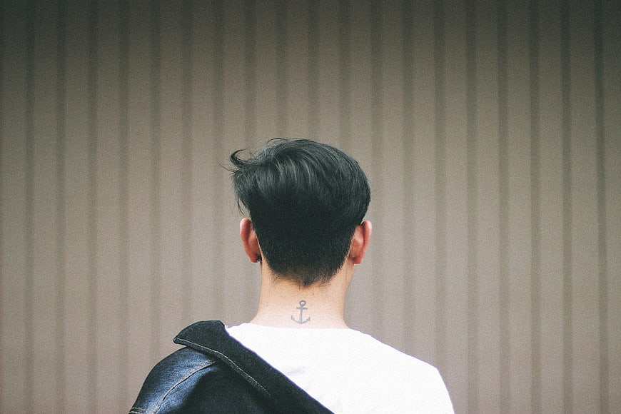 Back view of man with anchor tattoo and denim jacket