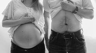 Pregnant Couple Showing Bellies in Black and White