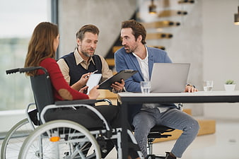 Business meeting with woman in wheelchair and two male colleagues