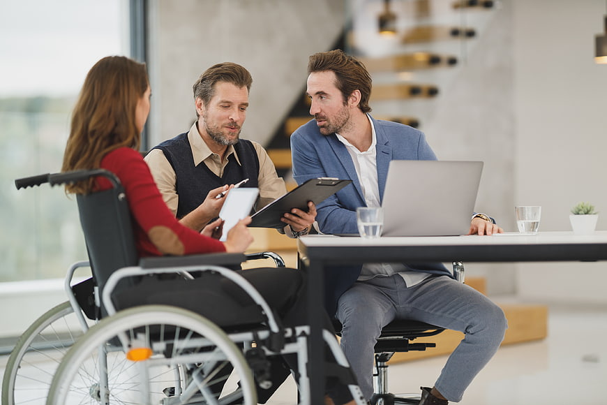 Business meeting with woman in wheelchair and two male colleagues