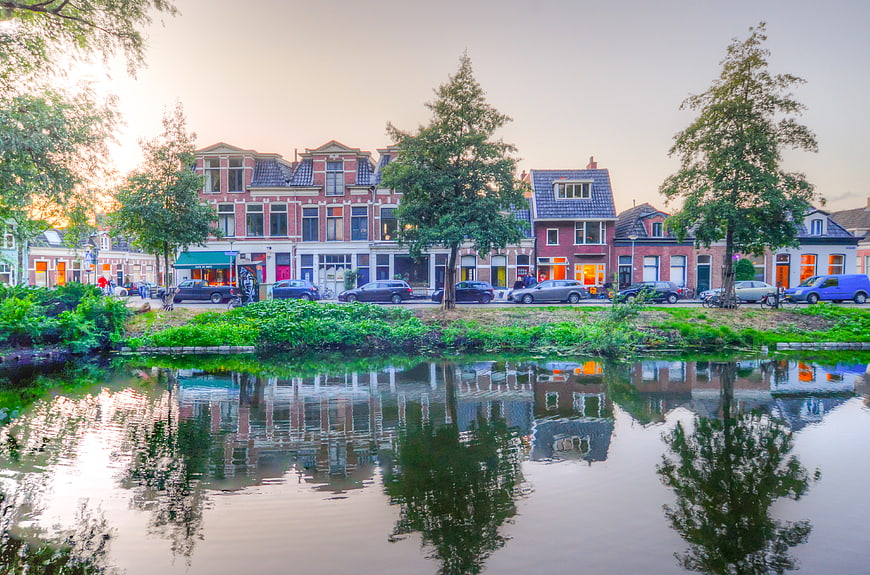 Dutch canal houses reflecting in water at sunset