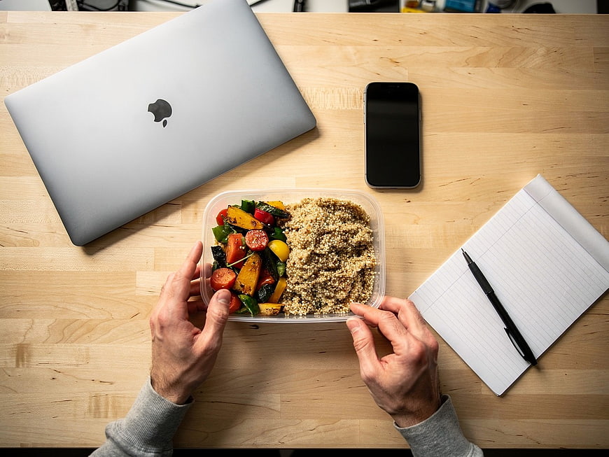 Overhead view of healthy quinoa salad lunch on office desk
